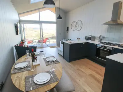 a kitchen with a wooden table with plates on it at Little Shelve Barn in Shrewsbury