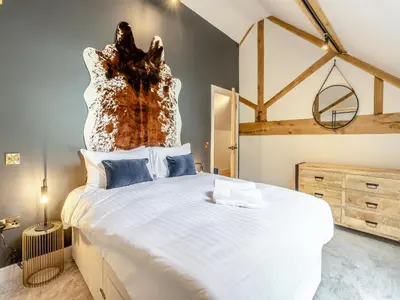 a bedroom with a large white bed with a wooden headboard at The Dairy - Uk44130 in Baystonhill