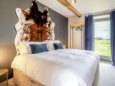 a bedroom with a large bed with a wooden headboard at The Dairy - Uk44130 in Baystonhill