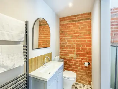 a bathroom with a white sink and a brick wall at The Stables - Uk44139 in Baystonhill