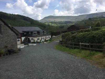 an empty road in a village with houses and hills at The Living Energy Holidays in Velindre