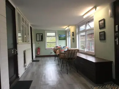 a dining room with a table and chairs and windows at The Living Energy Holidays in Velindre