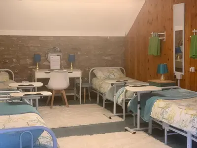 a room with several beds and tables and chairs at The Living Energy Holidays in Velindre