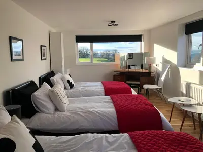 a bedroom with two beds and a desk and a window at The Living Energy Holidays in Velindre