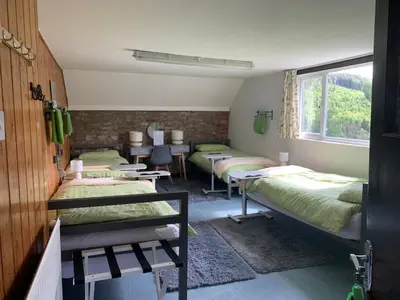 a group of beds in a room with a window at The Living Energy Holidays in Velindre