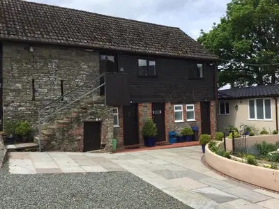 a brick house with a stone driveway at The Living Energy Holidays in Velindre