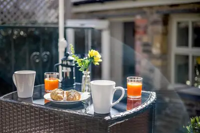 a table with cups and a plate of food and orange juice at 1 Bed in Cerrigydrudion oc-bow194 in Cerrig-y-Druidion