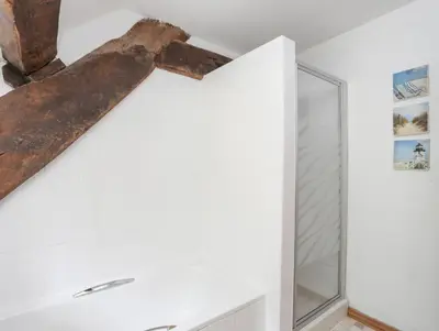 a timber beam hangs from the ceiling of a bathroom at Gilfachwydd in Dolgellau