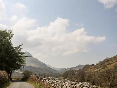a road in the mountains with a stone wall at Gilfachwydd in Dolgellau