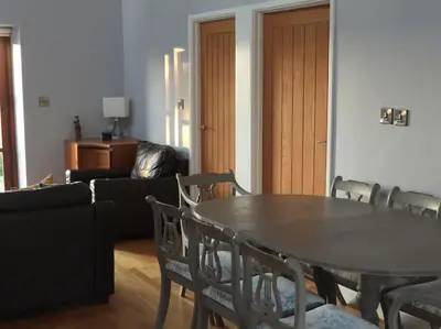 a living room with a table and chairs and a couch at Nature's Oasis: Pet-Friendly Snowdonia Cottage in Trawsfynydd