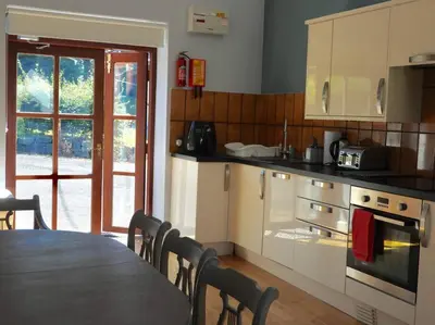 a kitchen with a table and a table and chairs at Nature's Oasis: Pet-Friendly Snowdonia Cottage in Trawsfynydd