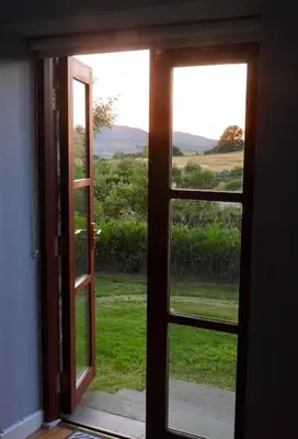 an open door with a view of a field of grass at Nature's Oasis: Pet-Friendly Snowdonia Cottage in Trawsfynydd