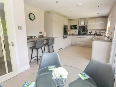 a kitchen and dining room with a glass table and chairs at Erwlon in Aberystwyth
