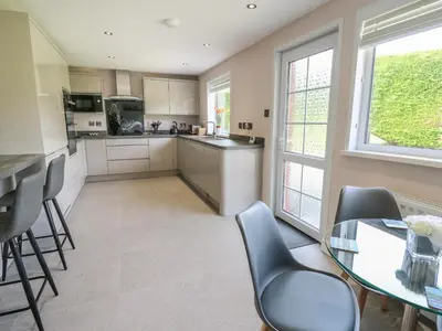 a kitchen with a table and chairs and a counter at Erwlon in Aberystwyth