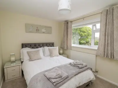 a bedroom with a large bed and a window at Erwlon in Aberystwyth