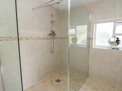 a bathroom with a shower with a glass door at Erwlon in Aberystwyth