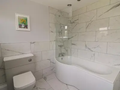 a white bathroom with a tub and a toilet at Erwlon in Aberystwyth