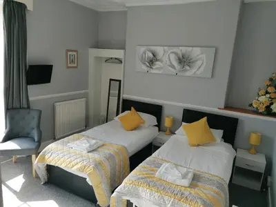 a hotel room with two beds and a chair at The George Borrow Hotel in Ponterwyd