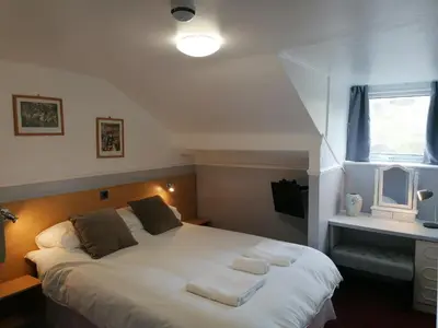 a bedroom with a bed with two towels on it at The George Borrow Hotel in Ponterwyd