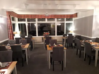 a restaurant with tables and chairs and a large window at The George Borrow Hotel in Ponterwyd