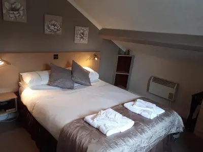 a bedroom with a large bed with towels on it at The George Borrow Hotel in Ponterwyd
