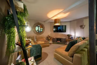 a living room with a couch and chairs and a mirror at At Home Apartments in Shrewsbury