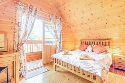 a bedroom with a bed in a log cabin at Robin Lodge in Llanbedr