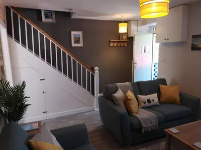 a living room with a couch and a staircase at Y Bwthyn in Llanbedr