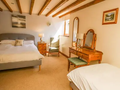 a bedroom with a bed and a mirror and a desk at Bodnant in Tywyn