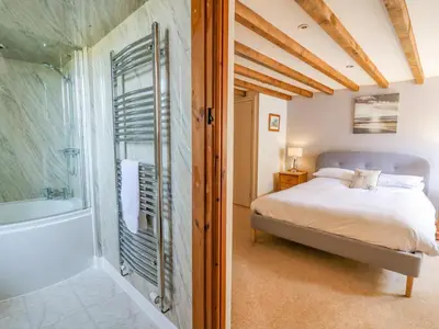 a bedroom with a bed and a shower and a tub at Bodnant in Tywyn