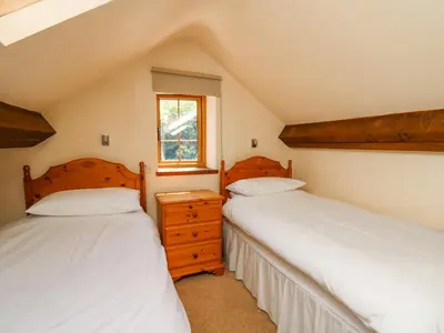 two twin beds in a room with a window at Bodnant in Tywyn