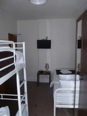 a room with three bunk beds and a table at Belle Vue Hotel in Llanwrtyd Wells