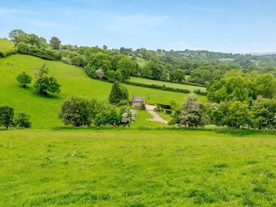 a green field with a house in the middle of it at The Cider House in Clee Saint Margaret