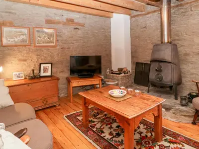 a living room with a table and a fireplace at Halls Mill in Kington