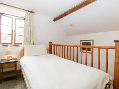 a bedroom with a bed and a desk and a window at Halls Mill in Kington