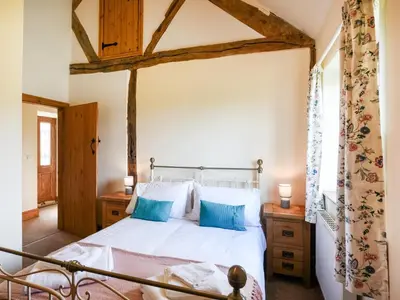 a bedroom with a large bed with blue pillows at Y Dderwen in Pen-y-bont-fawr