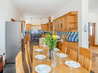 a kitchen with a table with plates and flowers on it at Rockcliffe in Aberdyfi