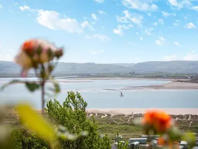 a view of a beach with a boat in the water at Rockcliffe in Aberdyfi