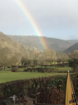 a rainbow in the sky with a field and trees at The Mulberry Inn in Glyn-Ceiriog