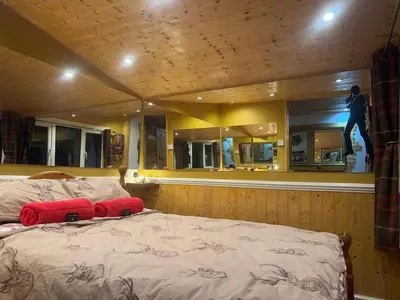 a bedroom with a bed in a boat at Cuckoo Cabin, Tyn Y Cwm in Scyborycoed