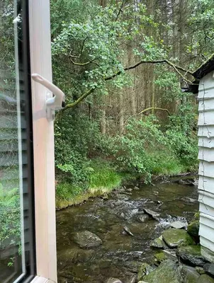 a view of a river from a window of a house at Cuckoo Cabin, Tyn Y Cwm in Scyborycoed