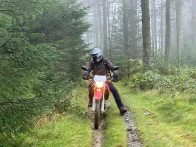 a person riding a dirt bike down a trail at Bear Cottage, Tyn Y Cwm in Scyborycoed