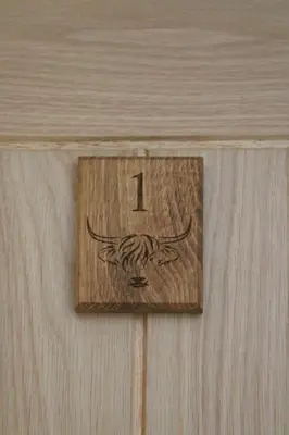 a wooden clock with the number one on a wall at The Moo-tel at Moody Meadows in Aberaeron