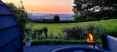a fire pit in a yard with a view of a field at Odli Glamping - Deri in Welshpool