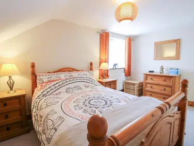 a bedroom with a large bed with a wooden frame at Mossy Lodge in Shrewsbury