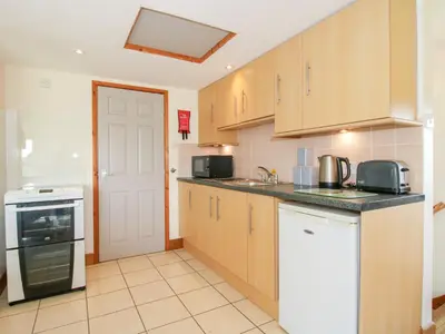 a kitchen with wooden cabinets and a white door at Mossy Lodge in Shrewsbury