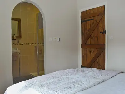 a bedroom with a bed and a door and a shower at Walkmill Lodge in Wentnor