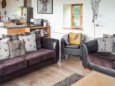 a living room with a couch and two chairs at Mashers Barn in Bucknell