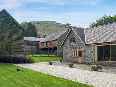 a stone house with a barn and a yard at Mashers Barn in Bucknell