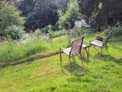 two chairs sitting in the grass in a garden at Garden Lodge in Llanvair Waterdine